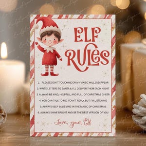 May include: A festive Christmas-themed card with an illustration of an elf wearing a red outfit and hat. The card features the words "Elf Rules" in red, along with six rules for the holiday season. The text "Love, your Elf" is also included.