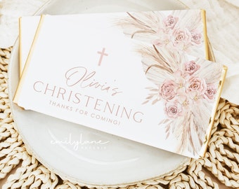 May include: White favor box with a gold border and a pink floral design. The text on the box reads "Olivia's Christening Thanks for coming!" and "emilylane paperie".
