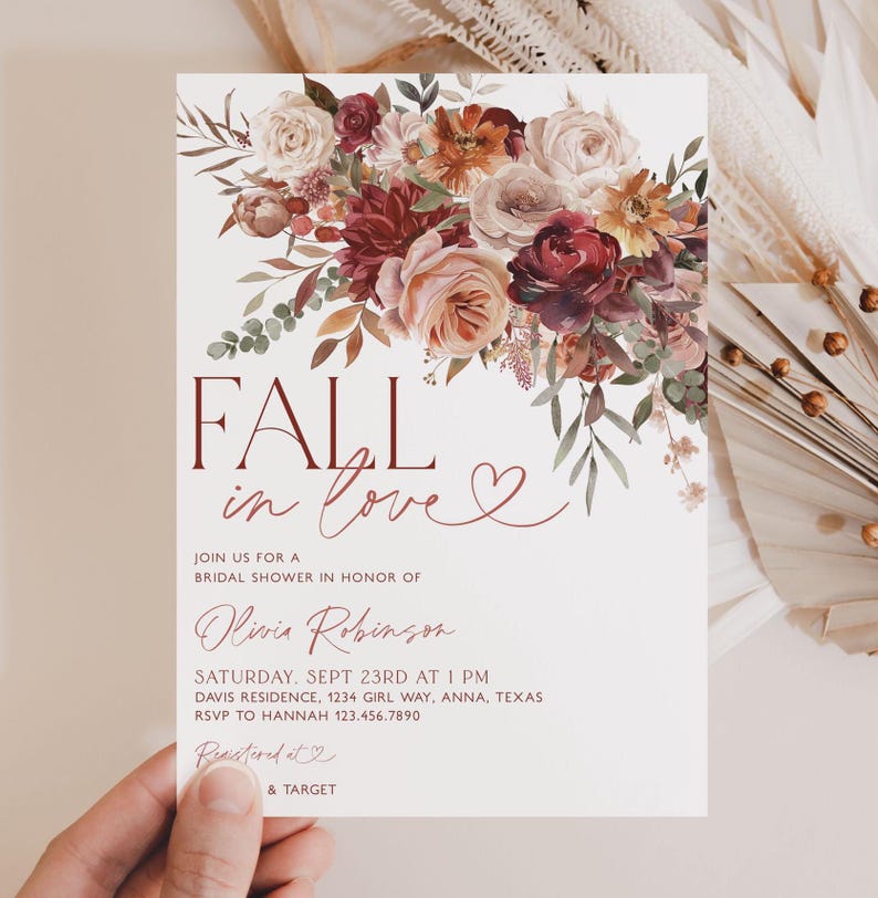 May include: Fall in love bridal shower invitation with a watercolor floral design in shades of burgundy, pink, and orange. The invitation features the text "Fall in love" with a heart symbol and details for the event, including the date, time, location, and RSVP information.