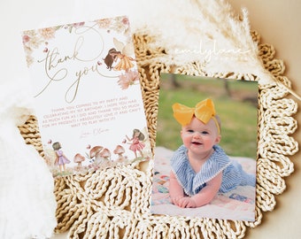 May include: Thank you card with a floral design and a picture of a baby girl wearing a yellow bow and a blue and white striped dress. The card says "Thank you coming to my party and celebrating my 1st birthday. I hope you had as much fun as I did and thank you so much for my present! I absolutely love it and can't wait to play with it! Love Olivia."