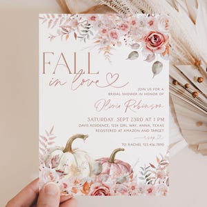 May include: Fall in love bridal shower invitation with a watercolor floral design featuring pumpkins and leaves in shades of pink, peach, and green. The invitation includes the text "Fall in love" and "Olivia Robinson".