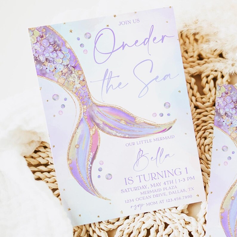 May include: Purple and gold mermaid tail illustration with glitter and stars on a light blue background. The text "Join Us Oneder the Sea" is at the top of the invitation. The text "Our Little Mermaid Bella Is Turning 1" is at the bottom of the invitation. The invitation also includes the date, time, and location of the party.