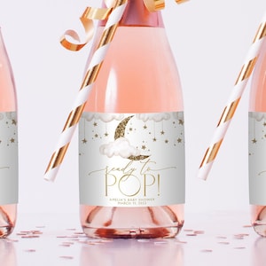 Könnte beinhalten: Ein weißes und goldenes Babyparty-Geschenk-Etikett mit einer Sichelmond, Wolken und Sternen. Das Etikett lautet "bereit zum Platzen!" und enthält den Text "Amelia's Baby Shower 11. März 2023".