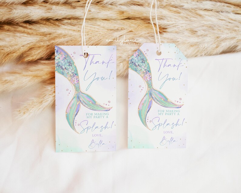 Puede incluir: Dos etiquetas de agradecimiento en forma de cola de sirena con un dise&ntilde;o de acuarela p&uacute;rpura y verde. El texto dice "&iexcl;Gracias!" y "Por hacer de mi fiesta un Splash! Con cari&ntilde;o, Bella".