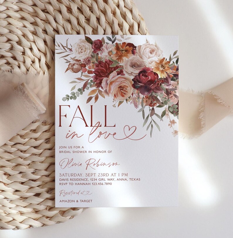 May include: Fall in love bridal shower invitation with a watercolor floral design in shades of burgundy, peach, and cream. The invitation features the text "Fall in love" with a heart symbol. The text also includes the bride's name, date, time, and location of the shower.