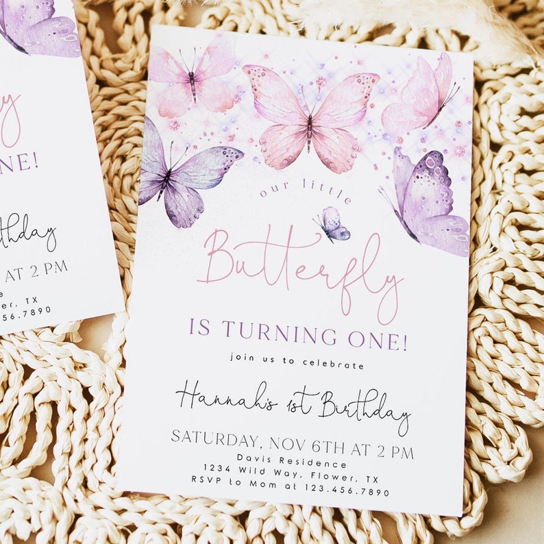 May include: A pink and purple butterfly-themed first birthday party invitation with watercolor butterflies and the text "Our little Butterfly is turning one! Join us to celebrate Hannah's 1st Birthday Saturday, Nov 6th at 2 PM Davis Residence 1234 Wild Way, Flower, TX RSVP to Mom at 123.456.7890"