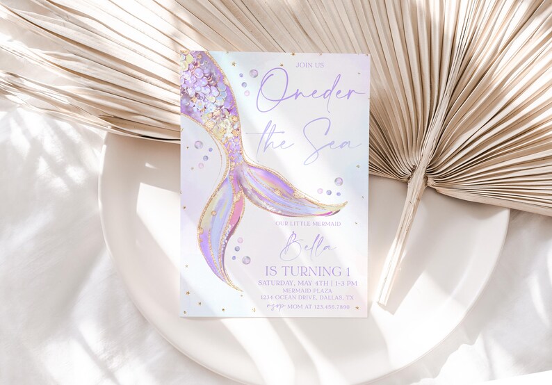May include: A purple and gold mermaid tail illustration with glitter and iridescent accents. The invitation reads "Oneder the Sea" and includes the name "Bella" and details for a first birthday party.