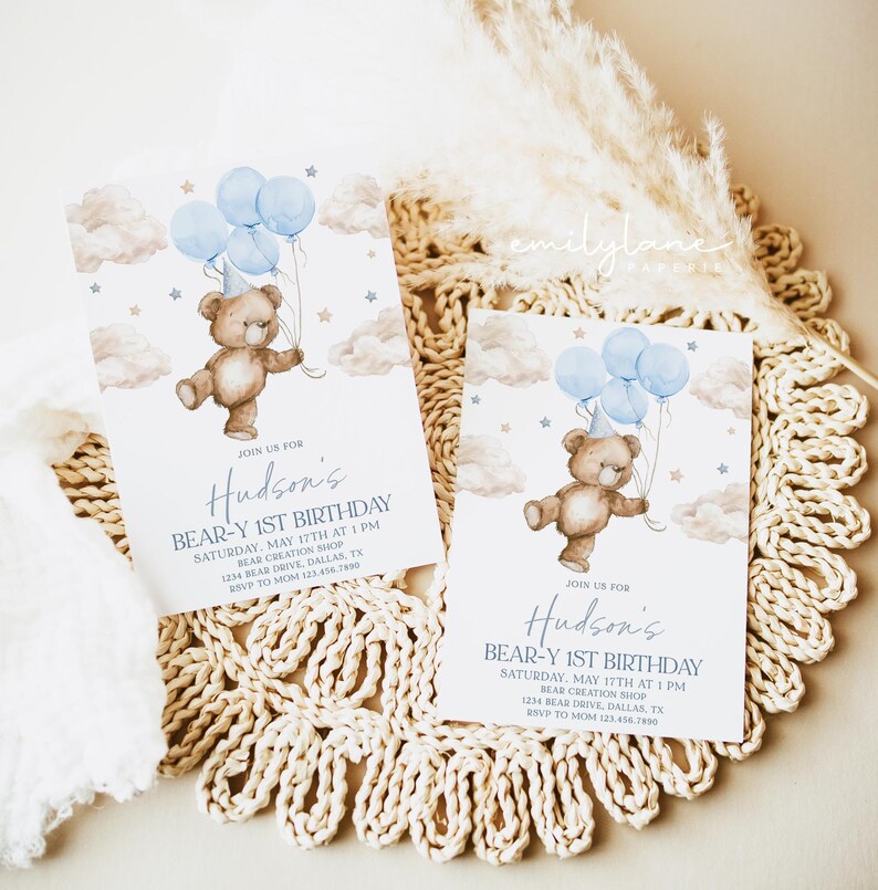 May include: Blue and brown teddy bear holding blue balloons with a party hat on its head. The bear is flying in the clouds with stars. The invitation says "Join us for Hudson's Bear-Y 1st Birthday. Saturday, May 17th at 1 PM. Bear Creation Shop. 1234 Bear Drive, Dallas, TX. RSVP to Mom 123.456.7890"
