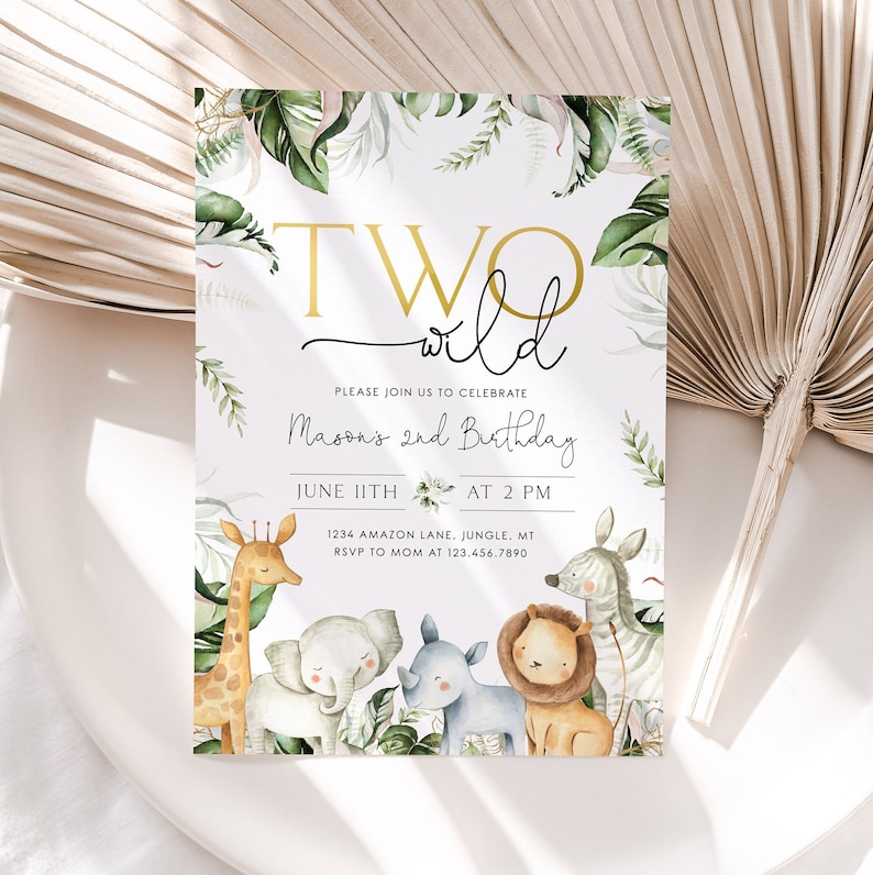 May include: A white invitation card with green foliage and animal illustrations. The text reads "Two wild" in gold lettering and "Mason's 2nd Birthday" in black lettering. The invitation includes the date, time, and location of the party.
