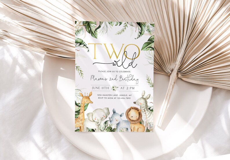May include: A white invitation card with green and gold accents. The card features the text "TWO wild" in gold lettering and the words "Please join us to celebrate Mason's 2nd Birthday" in black lettering. The card also includes a date and time for the event, as well as an address and RSVP information. The card is decorated with a watercolor illustration of jungle animals, including a giraffe, elephant, rhino, lion, and zebra.