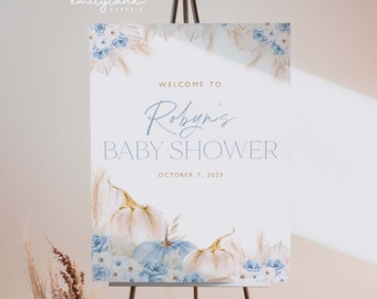 Puede incluir: Un cartel de bienvenida para una baby shower azul y blanco con el texto "Bienvenido a Robyn's Baby Shower" y la fecha "7 de octubre de 2023". El cartel está decorado con ilustraciones de acuarela de calabazas, flores y hierba de la pampa.