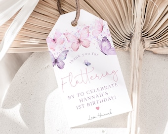 May include: Pink and purple butterfly thank you tags with the text "Thank you for fluttering by to celebrate Hannah's 1st birthday! Love, Hannah".