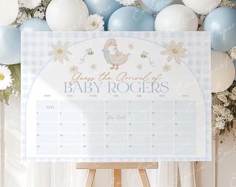 May include: A light blue and white baby shower calendar with the text "Guess the Arrival of BABY ROGERS." The calendar features a goose illustration, daisies, and bees. It is displayed on a wooden easel, with blue and white balloons in the background.