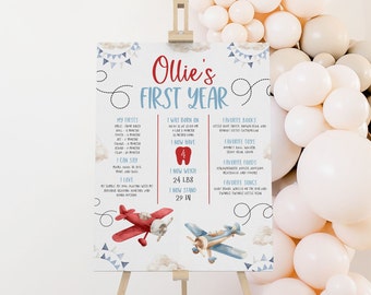 Puede incluir: Un cartel imprimible azul y blanco para el primer cumpleaños con una ilustración de un avión rojo y azul. El cartel incluye el nombre "Ollie's First Year" y detalles sobre el primer año del niño, incluyendo sus primeras veces, cuándo nació, su peso y altura, y sus libros, juguetes, alimentos y canciones favoritos.