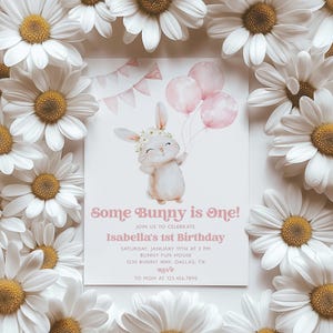 Op de afbeelding: Een roze en witte verjaardagsuitnodiging met een cartoonkonijn dat ballonnen vasthoudt. De uitnodiging luidt "Some Bunny is One!" en bevat de tekst "Join us to celebrate Isabella's 1st Birthday" en details voor het feest.