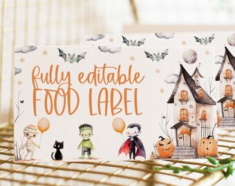 May include: Editable Halloween food label template with a cute cartoon illustration of a haunted house, a mummy, a black cat, Frankenstein, and a vampire. The text reads "fully editable food label".