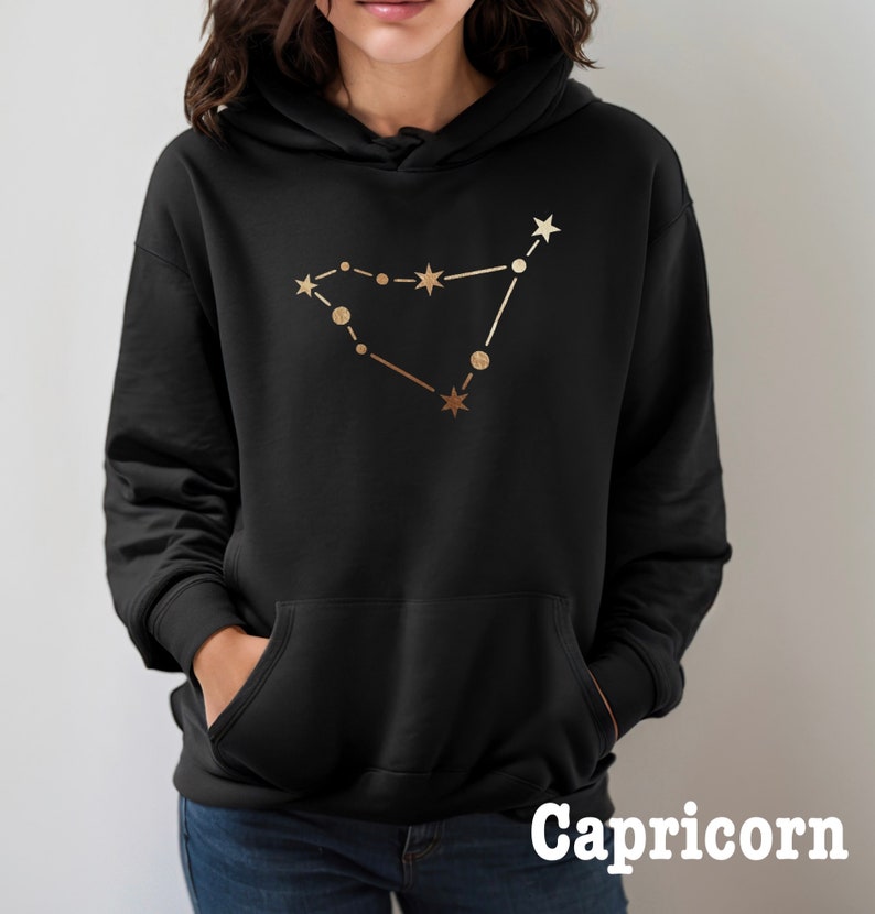 May include: Black hoodie with a gold Capricorn constellation design. The text "Capricorn" is printed below the design.