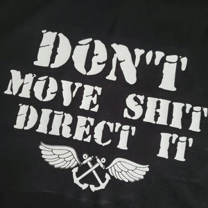 May include: Black t-shirt with white text that reads "Don't Move Shit Direct It" with a white anchor and wings below the text.