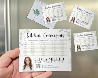 May include: A set of kitchen conversion magnets with a floral design. The main magnet displays a conversion chart with measurements in cups, fluid ounces, tablespoons, teaspoons, and milliliters. The text "Kitchen Conversions" is at the top. The bottom features a real estate agent's information.