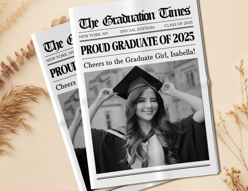 May include: Two newspapers titled "The Graduation Times" with the headline "Proud Graduate of 2025." The newspapers feature a black and white photo of a smiling graduate wearing a cap and gown. The text reads "Cheers to the Graduate Girl, Isabella!"