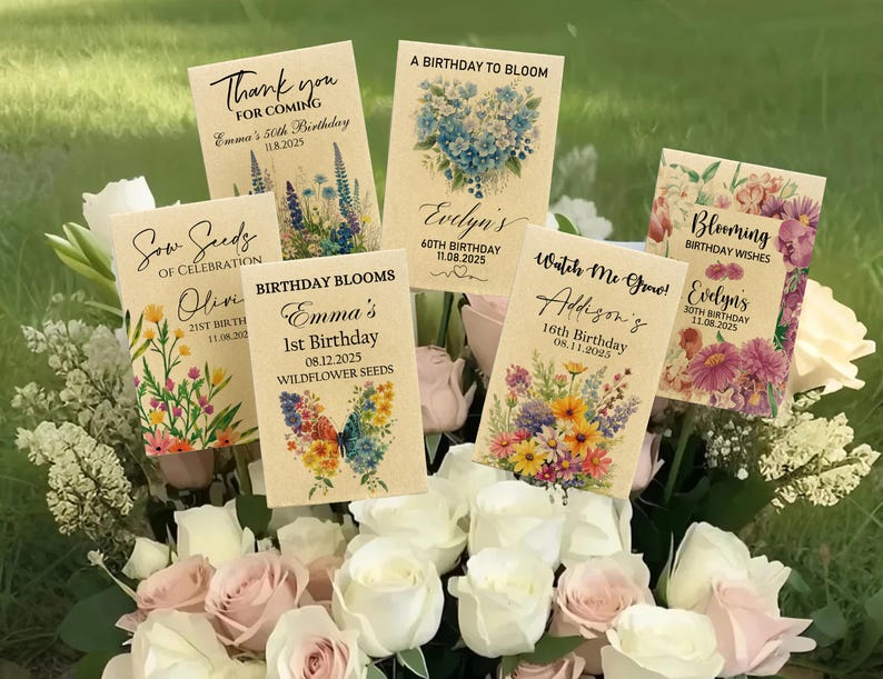 Puede incluir: Una colecci&oacute;n de recuerdos de paquetes de semillas personalizados con dise&ntilde;os florales y texto. Los paquetes presentan frases como "Gracias", "Birthday Blooms" y nombres con fechas de cumplea&ntilde;os. Los paquetes est&aacute;n dispuestos en un ramo de rosas blancas y rosas.