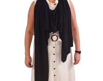 May include: A black scarf draped over a white dress with a brown belt. The scarf is long and flowing, and the dress has a button-up front.