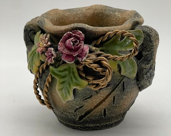 Rustic earthy rough pottery bowl flower pot with flowers and rope design.