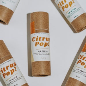 May include: Five brown cardboard tubes with orange labels that say "Citrus Pop!" and "Lip Scrub" with the text "I self-care for social good" on the side.
