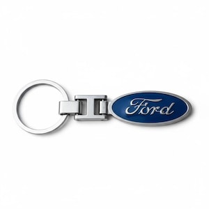 Puede incluir: Un llavero de metal plateado con un emblema ovalado azul con la palabra "Ford" en escritura blanca. El llavero tiene un anillo partido y un conector rectangular.