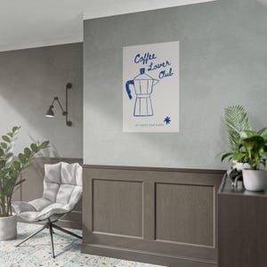 Könnte beinhalten: Ein weißes Poster mit einer blauen Illustration einer Espressokanne. Der Text "Coffee Lover Club" steht über der Illustration, darunter "AT LEAST ONE A DAY". Ein blauer Stern befindet sich rechts von der Espressokanne.