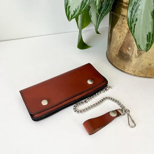 Cartera vintage de cuero marrón con cadena plateada y llavero