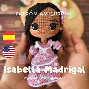 May include: Crochet amigurumi doll pattern for Isabella Madrigal from Disney's Encanto. The doll is wearing a purple dress with floral embroidery and has brown skin and black hair. The pattern is available in both English and Spanish.