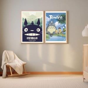 K&ouml;nnte beinhalten: Zwei gerahmte Kunstdrucke mit Charakteren aus dem Zeichentrickfilm "Mein Nachbar Totoro". Ein Druck zeigt Totoro mit einem Waldhintergrund und japanischem Text. Der andere zeigt Totoro mit zwei Kindern in der N&auml;he eines Sees. Beide sind in Holzrahmen.