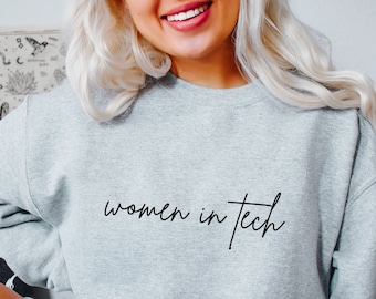 May include: A grey sweatshirt with the text "women in tech" in black script.