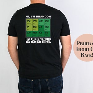 May include: Black t-shirt with a green and white periodic table design featuring programming languages. The text "HI, I'M BRANDON" and "I'M THE ONE WHO CODES" is printed on the shirt.