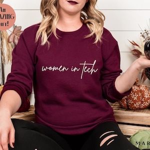 May include: A maroon sweatshirt with the text "women in tech" in white script.