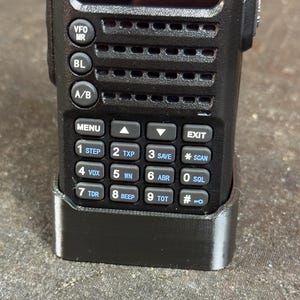 May include: A black handheld radio with a screen displaying "146.96000 OFF 400.05000" and a keypad with buttons labeled "MENU", "EXIT", "STEP", "TXP", "SAVE", "SCAN", "VOX", "WN", "ABR", "SQL", "TDR", "BEEP", "TOT", and "#"