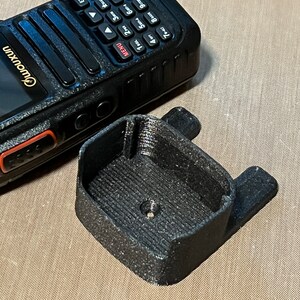 Pode incluir: Um r&aacute;dio port&aacute;til preto com teclado e tela, ao lado de um suporte preto impresso em 3D. O r&aacute;dio tem a marca "Owouxun". O suporte tem formato retangular com duas abas laterais. Dispositivo de comunica&ccedil;&atilde;o.