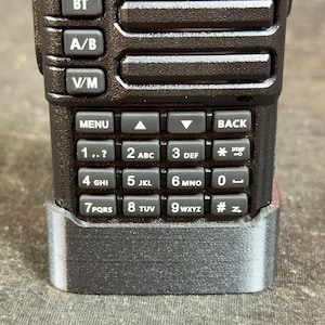 May include: Close-up of a black handheld radio with a keypad and buttons labeled "BT", "A/B", "V/M", "MENU", and "BACK". The keypad has numbers and letters, including "1..?", "2 ABC", "3 DEF", "4 GHI", "5 JKL", "6 MNO", "7PQRS", "8 TUV", "9 WXYZ", "0", and "#z".