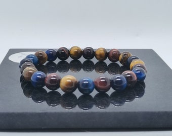 Puede incluir: Un brazalete de cuentas con cuentas de ojo de tigre azul, marrón y dorado.