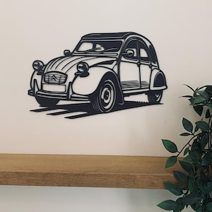 May include: Black metal silhouette wall art of a classic car, a vintage French Citroen 2CV, with a wooden shelf below.