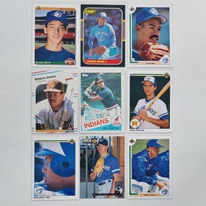 May include: A collection of nine baseball trading cards, displaying players in their team kits. The cards feature players from the Blue Jays and Indians, including Roberto Alomar, Joe Carter, and John Olerud. The cards are in good condition.