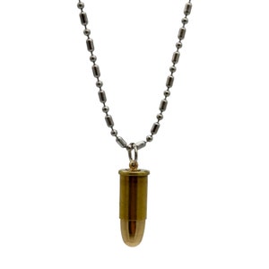 May include: A silver chain necklace with a gold bullet pendant.