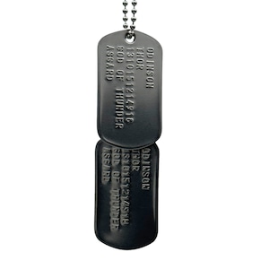 Può includere: Due medaglie per cani d'argento con una catena. La medaglia superiore recita "ODINSON THOR 1310151214916 GOD OF THUNDER ASGARD". La medaglia inferiore recita "ODINSON THOR 1810151214510 GOD OF THUNDER ASCARP".