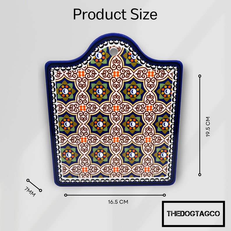 Puede incluir: Una tabla de cortar de cer&aacute;mica azul y blanca con un patr&oacute;n geom&eacute;trico. La tabla mide 16,5 cm por 19,5 cm.