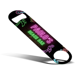 May include: Black bottle opener featuring neon-style graphics. The design includes a palm tree, flamingo, and the text "PAOLO'S BEACH BAR" in pink and green. The opener has a bottle cap remover and a hole for hanging.