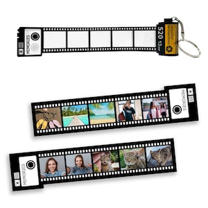 May include: Black and white film strip with a black camera icon and the word "Memories" printed on it. The film strip has six empty frames and a small yellow and black 35mm film canister keychain with the text "35mm Film for Colour Prints 520 13 Exp" printed on it.
