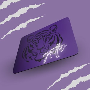 Puede incluir: Una tarjeta morada con una silueta de tigre negro y la palabra "gretta" en letras de neón blancas con un corazón.