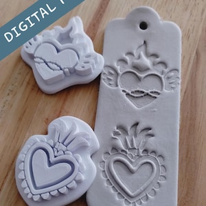 May include: Three light gray heart-shaped molds with intricate designs, including a heart with wings, a heart with a crown, and a heart with a decorative border. The molds are on a wooden surface. The text "DIGITAL FILE" is in the upper left corner.