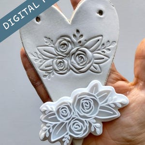 May include: A white heart-shaped ceramic piece with a floral design, held in a hand. The design features embossed roses and leaves. A matching floral-shaped cutter is also visible. The text "DIGITAL FILE" is printed on the image.